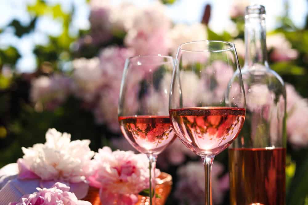 rosé with pink flowers in background outside