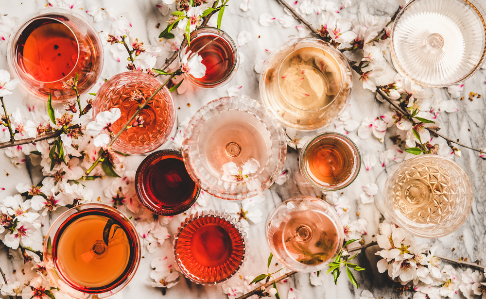 multiple rose wines on a table with flowers